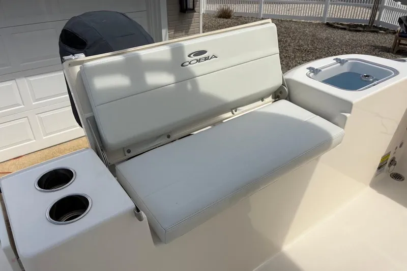 Slide: The Image of 2022 Cobia 220 Center Console boat interior with seating and cup holders. - 20