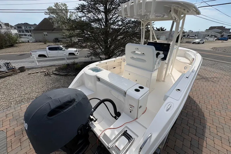 Slide: The Image of 2022 Cobia 220 Center Console boat parked on a brick driveway, showcasing its sleek design. - 5