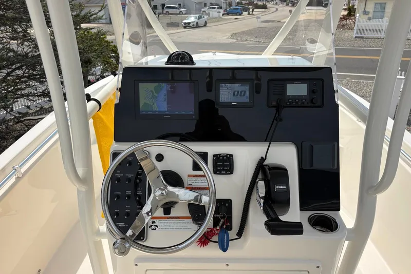 Slide: The Image of 2022 Cobia 220 Center Console boat dashboard with steering wheel and navigation equipment. - 8