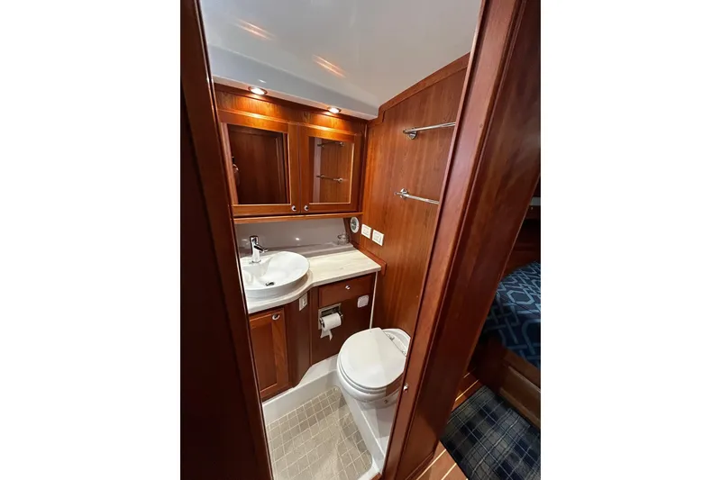 Slide: The Image of 2021 Sabre 45 Salon Express bathroom with wood cabinetry and modern fixtures. - 2