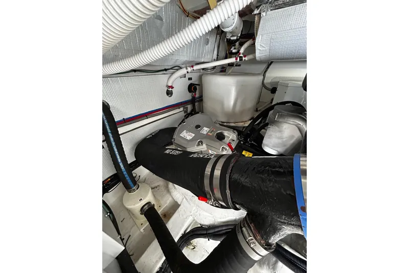 Slide: The Image of Engine room of 2021 Sabre 45 Salon Express with visible hoses and components. - 23