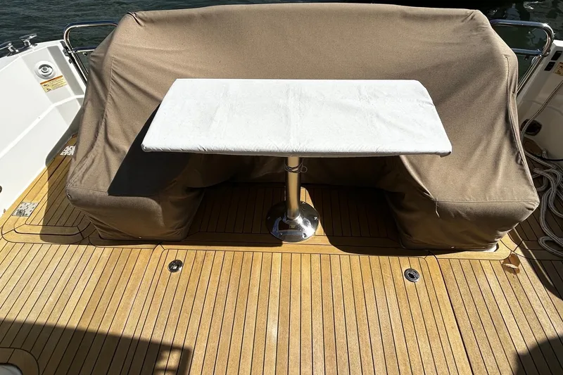 Slide: The Image of 2021 Sabre 45 Salon Express yacht deck with covered seating and table. - 24