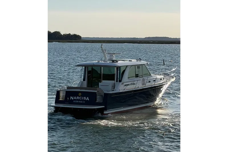 Slide: The Image of 2021 Sabre 45 Salon Express yacht cruising on calm waters at sunset. - 34