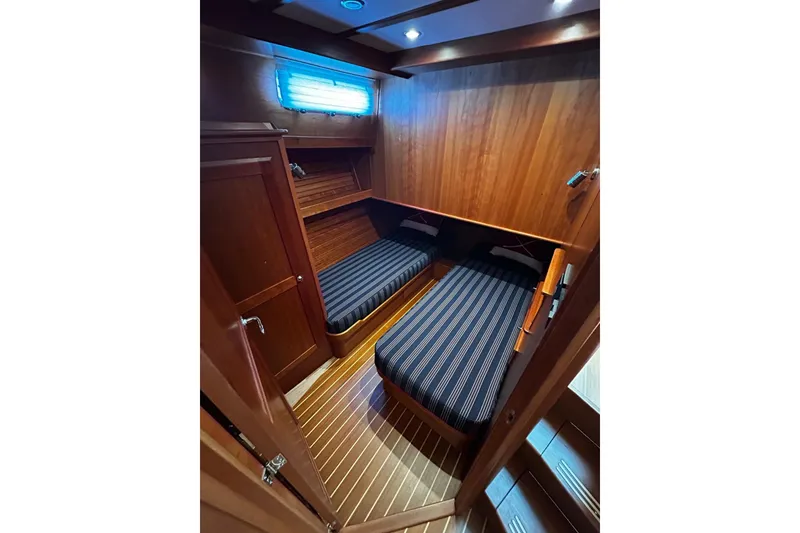 Slide: The Image of 2021 Sabre 45 Salon Express cabin with twin beds, wooden interior, and striped bedding. - 4