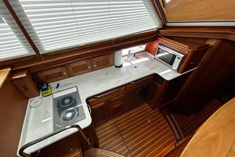 Slide: The Image of Modern galley kitchen in 2021 Sabre 45 Salon Express yacht with wood cabinetry and appliances. - 7