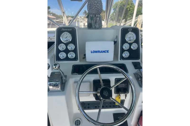 Slide: The Image of Shamrock 290 Walkaround 2000 boat dashboard with steering wheel and Lowrance display. - 16