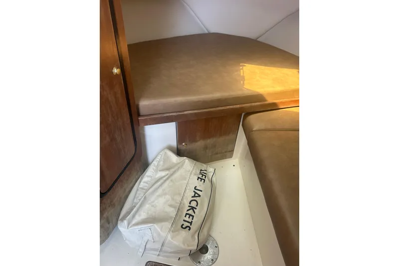 Slide: The Image of Interior of 2000 Shamrock 290 Walkaround boat with life jackets stored below seating. - 18