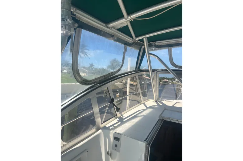 Slide: The Image of 2000 Shamrock 290 Walkaround boat interior with clear canopy and waterfront view. - 22