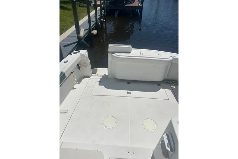 Slide: The Image of 2000 Shamrock 290 Walkaround boat deck, docked by calm waters. - 25