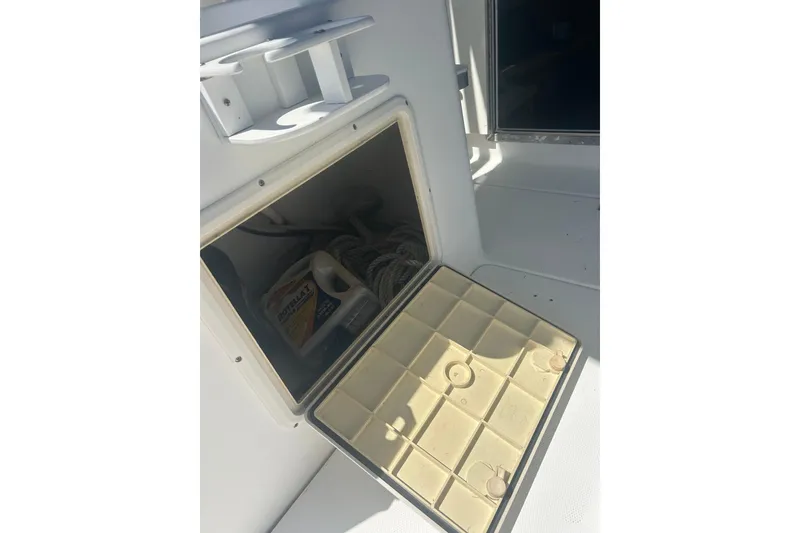 Slide: The Image of Storage compartment on a 2000 Shamrock 290 Walkaround boat, containing ropes and supplies. - 26