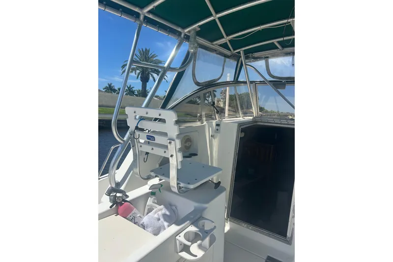 Slide: The Image of 2000 Shamrock 290 Walkaround boat interior with helm, canopy, and open cabin door. - 27