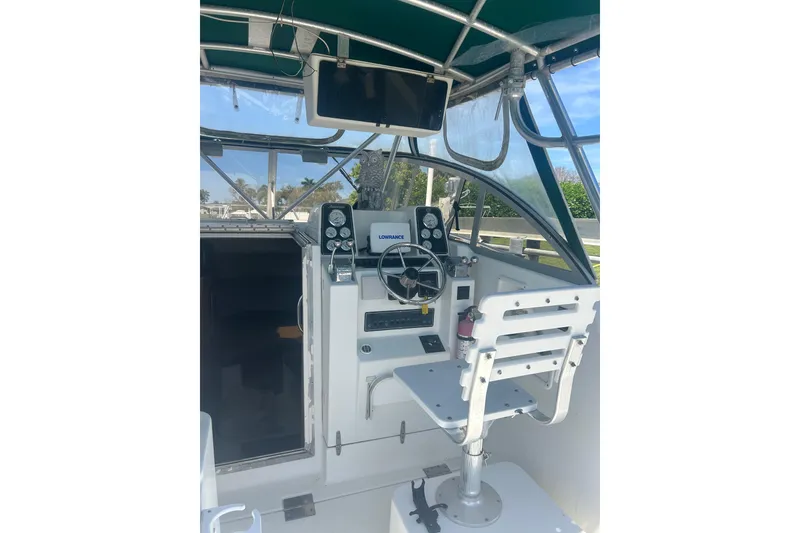 Slide: The Image of 2000 Shamrock 290 Walkaround boat cockpit with steering wheel and navigation equipment. - 28