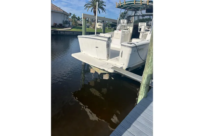 Slide: The Image of 2000 Shamrock 290 Walkaround boat docked near waterfront homes and palm trees. - 3