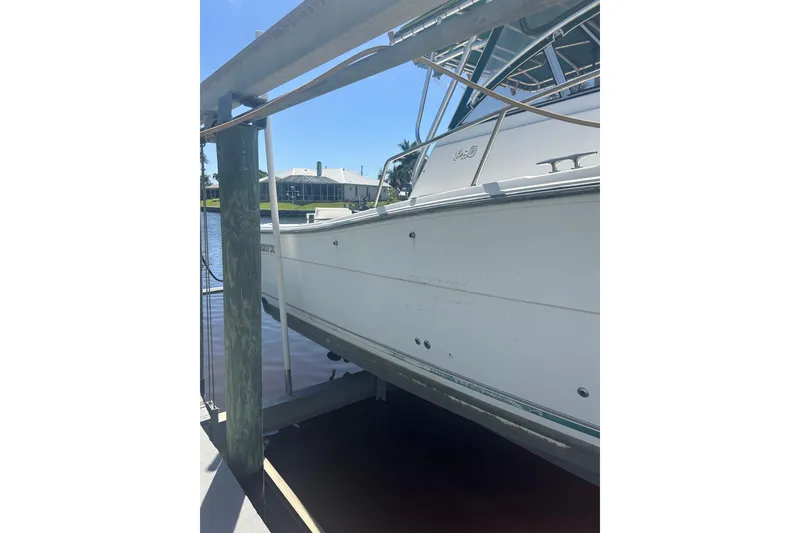 Slide: The Image of 2000 Shamrock 290 Walkaround boat docked, side view with clear sky background. - 30