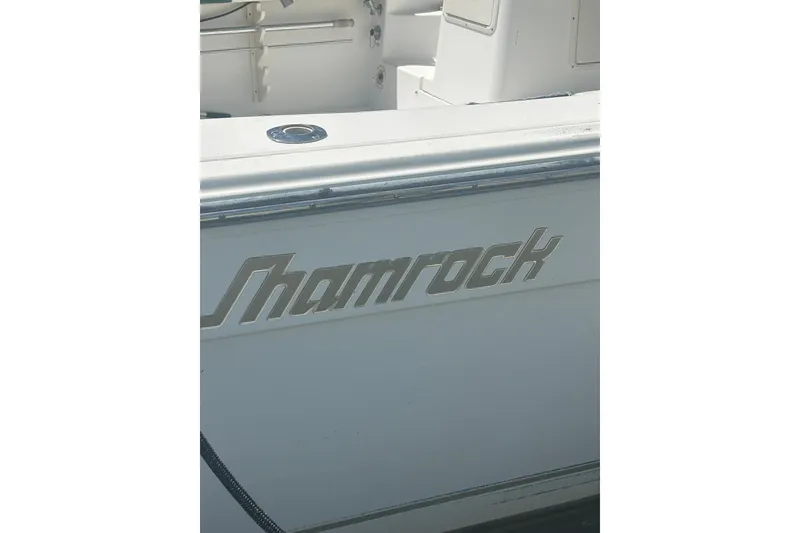 Slide: The Image of 2000 Shamrock 290 Walkaround boat with logo on the side. - 32
