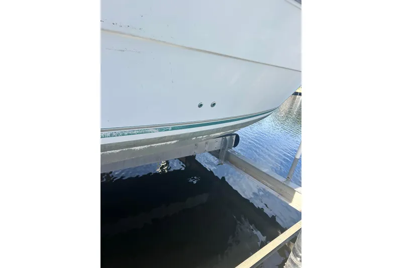 Slide: The Image of 2000 Shamrock 290 Walkaround boat hull on lift above water. - 5