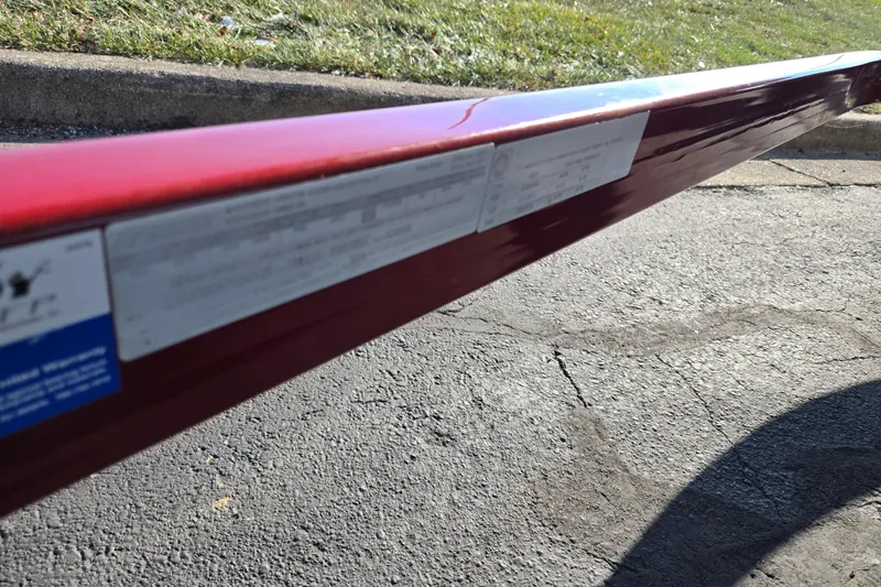 Slide: The Image of Close-up of a red Glastron GT 205 Ski & Fish 2007 boat trailer on pavement. - 8