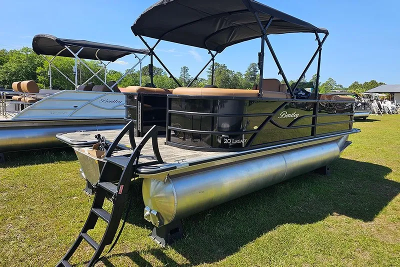 Slide: The Image of 2026 Bentley Pontoons Legacy 200 Navigator on grassy area, featuring sleek design and canopy. - 3