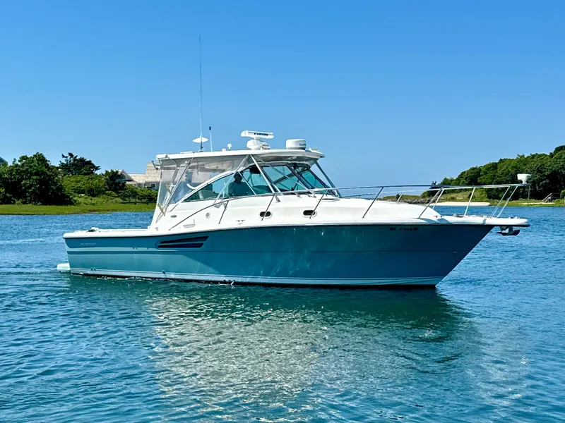 Slide: The Image of 2003 Pursuit 3400 Express boat cruising on clear blue water under a sunny sky. - 4