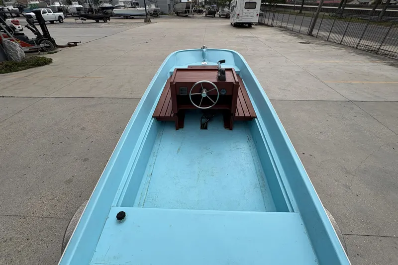 Slide: The Image of 1963 Boston Whaler 16 boat with blue interior and wooden steering console. - 11
