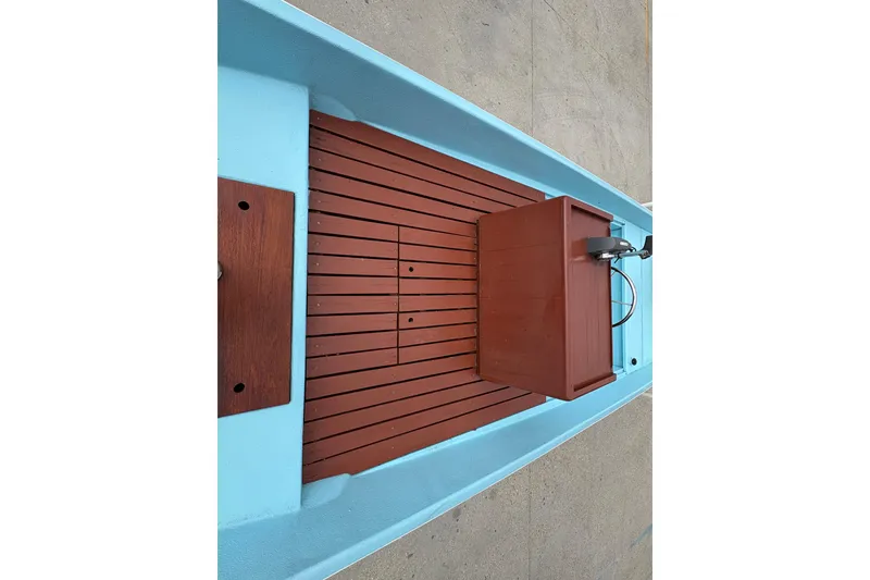 Slide: The Image of 1963 Boston Whaler 16 boat interior with wooden deck and blue hull. - 15