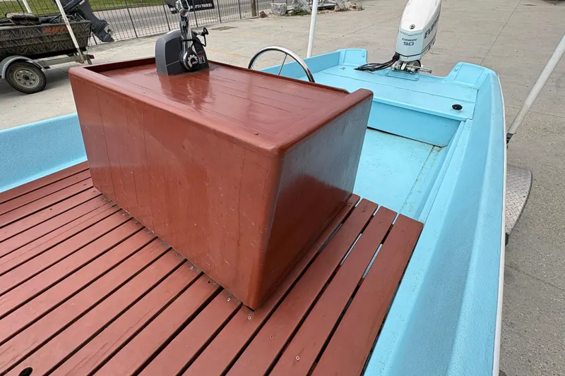 Slide: The Image of 1963 Boston Whaler 16 boat with wooden deck and blue interior. - 16