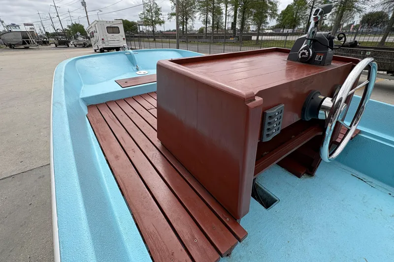 Slide: The Image of 1963 Boston Whaler 16 boat with wooden console and blue interior, parked outdoors. - 19