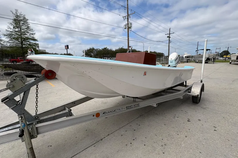 Slide: The Image of 1963 Boston Whaler 16 boat on trailer, parked outdoors under cloudy sky. - 7