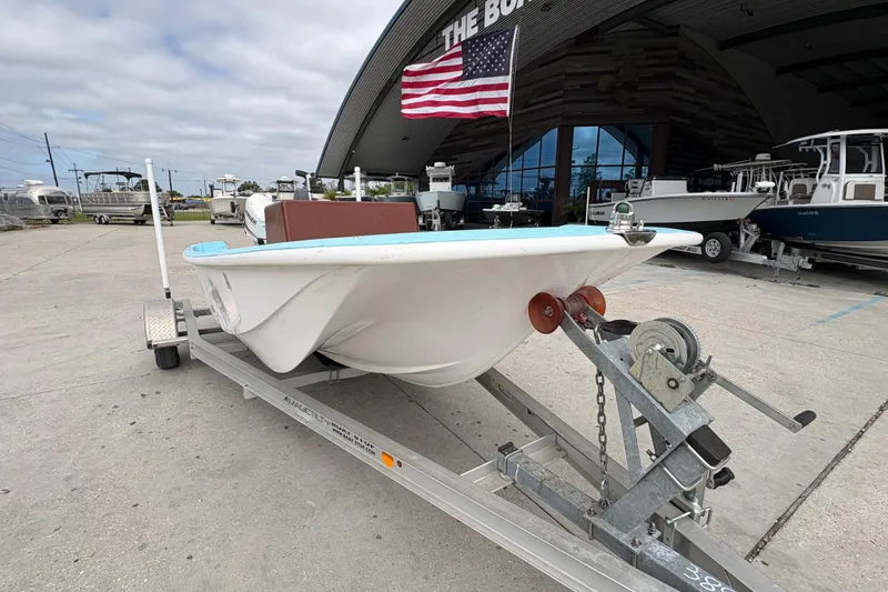 Slide: The Image of 1963 Boston Whaler 16 boat on trailer, displayed outdoors with American flag. - 9