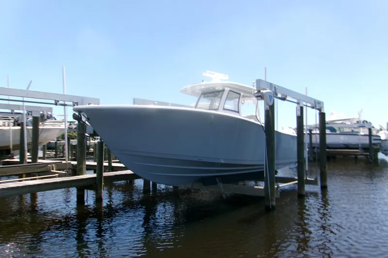 The Image of 2022 Sportsman Open 322 Center Console boat on lift at marina. - 0