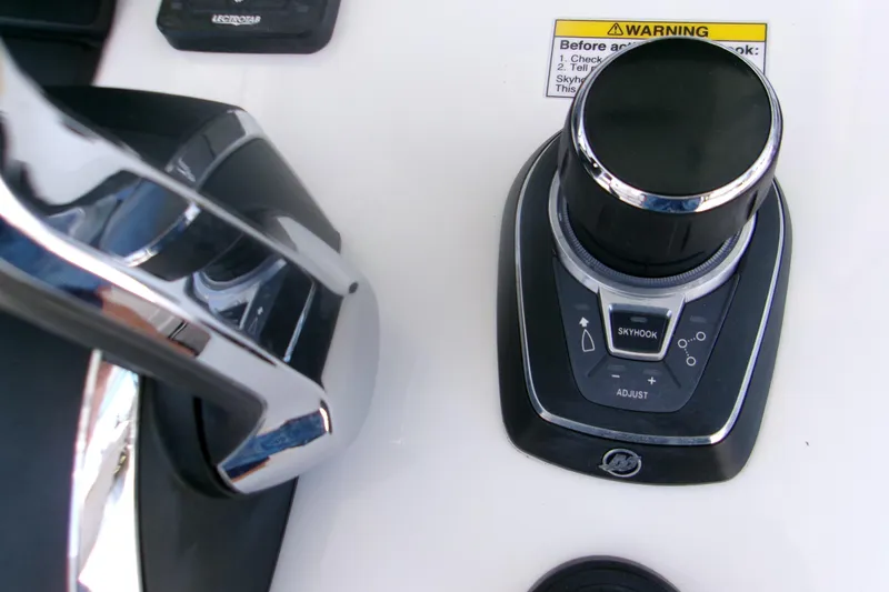 Slide: The Image of Control panel of 2022 Sportsman Open 322 Center Console boat with joystick and warning label. - 12