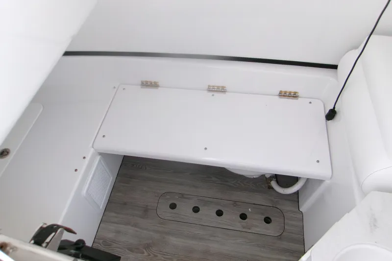 Slide: The Image of 2022 Sportsman Open 322 Center Console interior with white seating and wood-patterned flooring. - 13