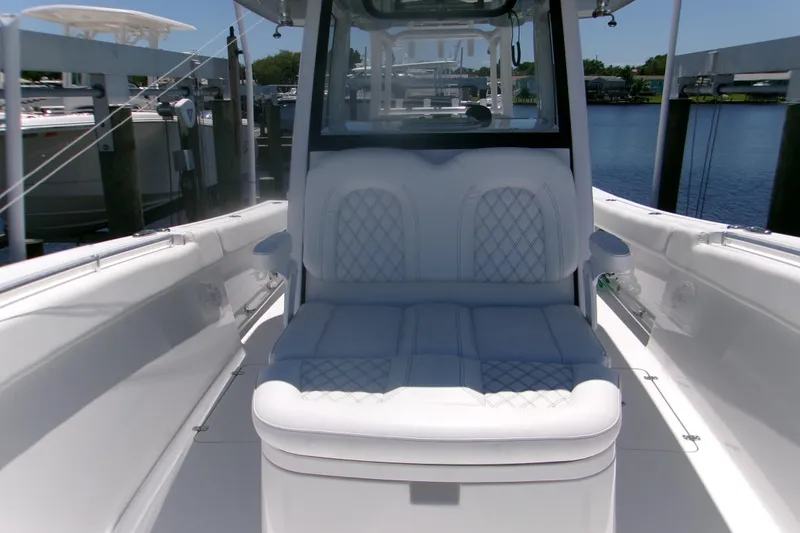 Slide: The Image of 2022 Sportsman Open 322 Center Console boat with luxurious seating, docked by the water. - 5