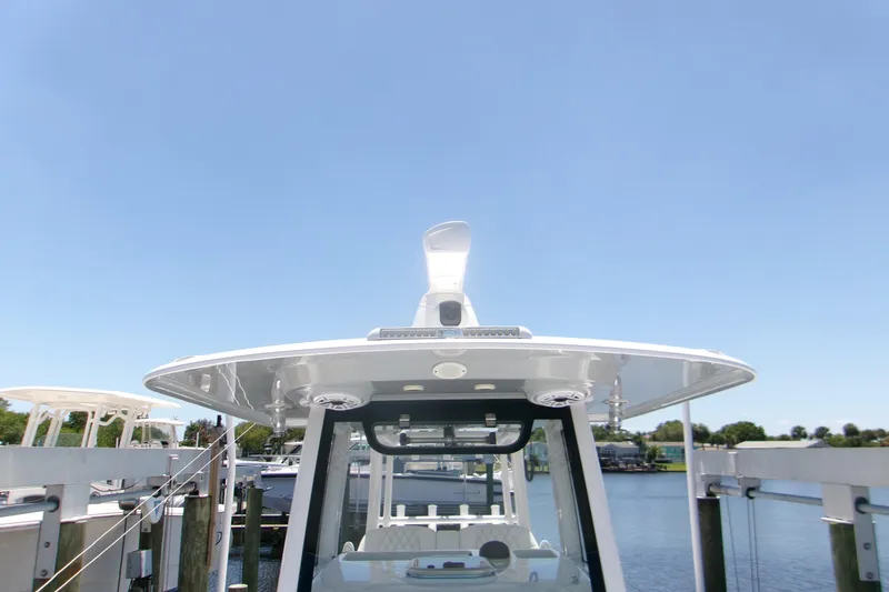 Slide: The Image of 2022 Sportsman Open 322 Center Console boat docked under clear blue sky. - 6