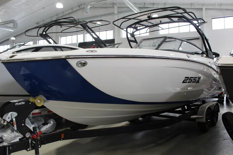 The Image of 2026 Yamaha Boats 255XE in showroom, featuring sleek design and modern architecture. - 0