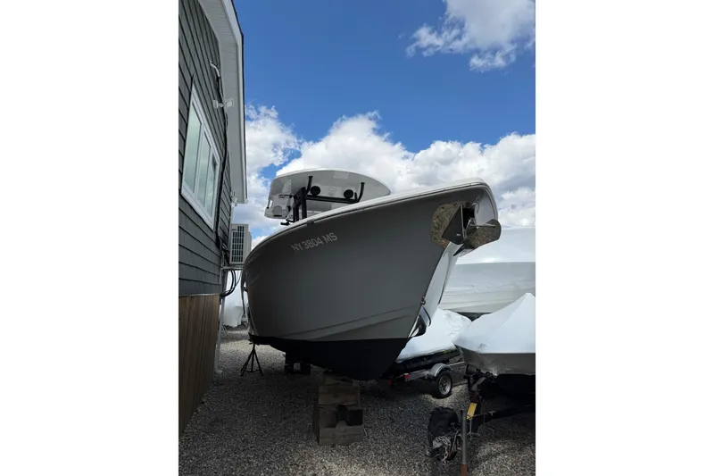 The Image of 2022 Seapro 239 DLX boat on dry dock beside a building under a blue sky. - 0