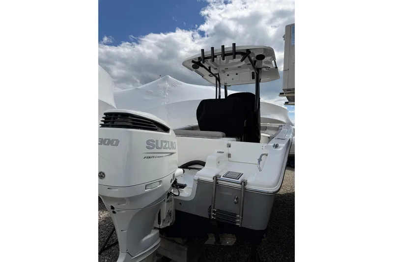 Slide: The Image of 2022 Seapro 239 DLX boat with Suzuki engine, parked outdoors under cloudy sky. - 15