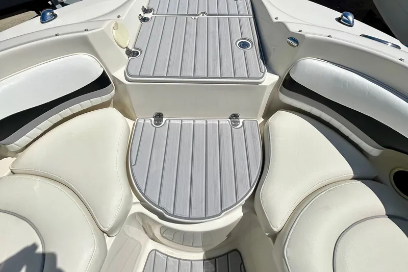 Slide: The Image of Interior view of 2012 Stingray 234 LR boat, featuring white cushioned seating and gray deck panels. - 13