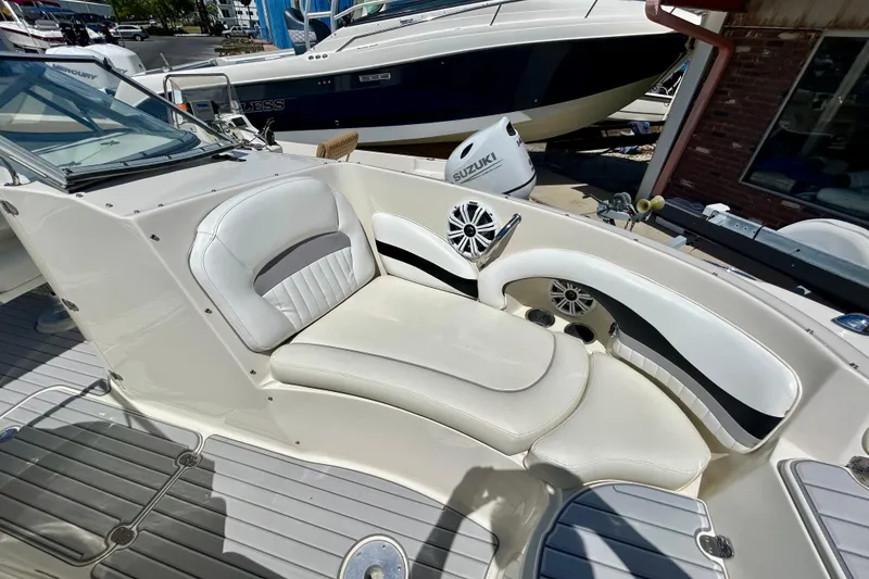 Slide: The Image of 2012 Stingray 234 LR boat interior with white seating and speaker system. - 15