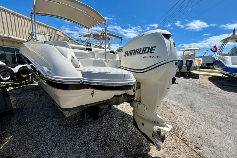 Slide: The Image of 2012 Stingray 234 LR boat with Evinrude E-TEC engine, parked outdoors. - 3