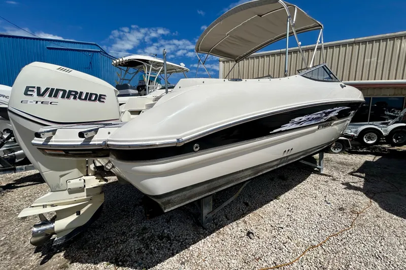 Slide: The Image of 2012 Stingray 234 LR boat with Evinrude E-TEC engine, parked outdoors. - 4
