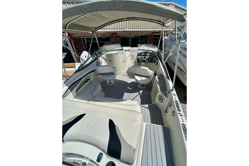 Slide: The Image of 2012 Stingray 234 LR boat interior with seating and steering wheel under canopy. - 5