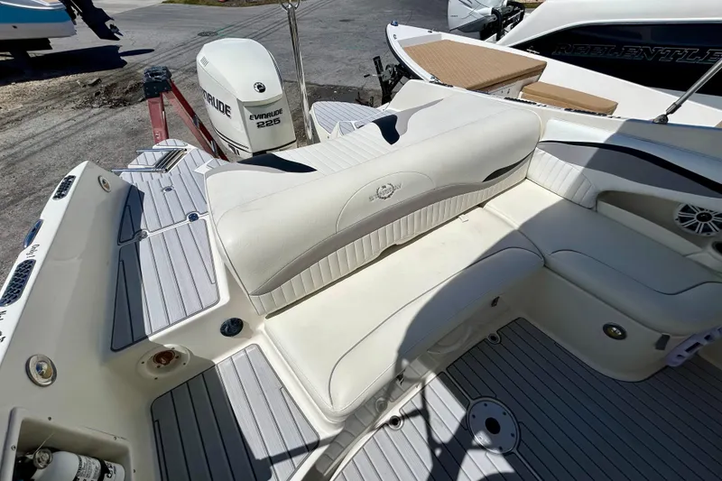 Slide: The Image of 2012 Stingray 234 LR boat interior with Evinrude 225 engine, featuring white seating and deck. - 6