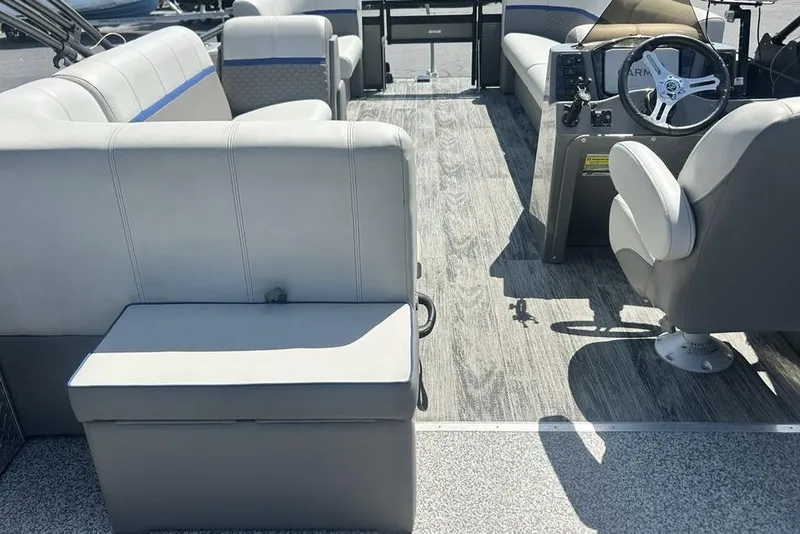 Slide: The Image of Interior of 2023 Angler Qwest 8524 Pro Family Fish Triple Tube boat, featuring seating and steering console. - 12