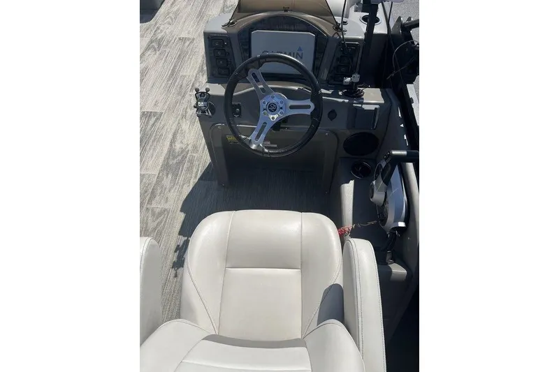 Slide: The Image of 2023 Angler Qwest 8524 Pro Family Fish Triple Tube boat cockpit with steering wheel and controls. - 5
