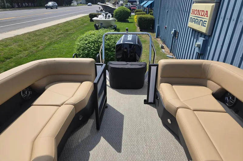 Slide: The Image of Evotti 523QL 2026 pontoon boat with tan seating, parked near Honda Marine. - 21