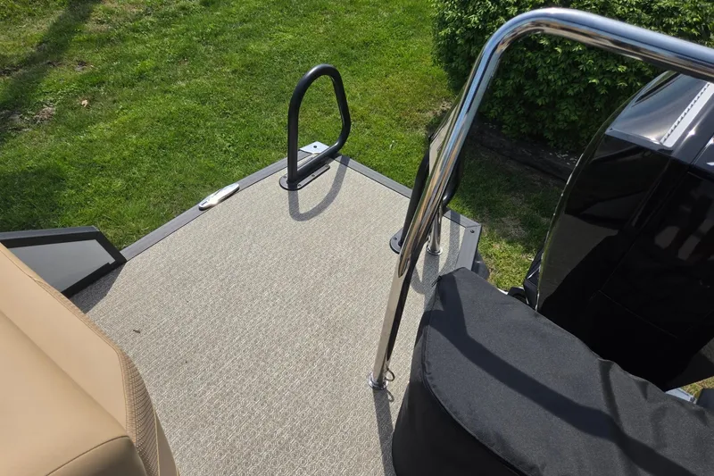 Slide: The Image of Rear deck of 2026 Evotti 523QL boat with railing and grass background. - 25