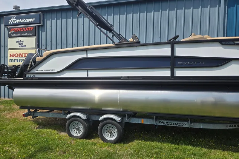 Slide: The Image of 2026 Evotti 523QL pontoon boat on trailer, displayed outside marina. - 3