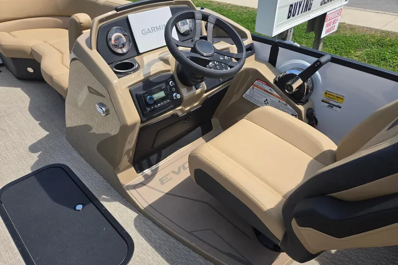 Slide: The Image of 2026 Evotti 523QL boat cockpit with steering wheel, Garmin display, and beige seating. - 35