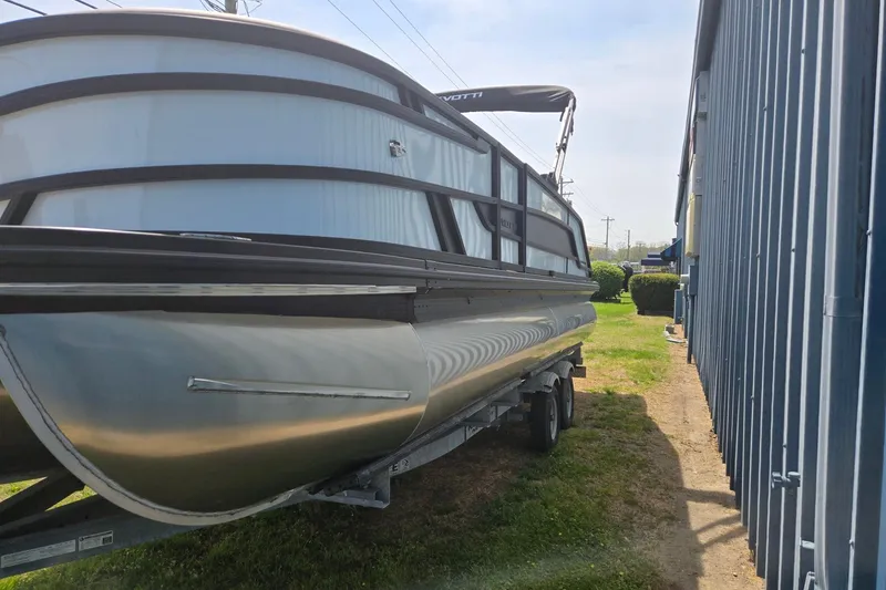Slide: The Image of 2026 Evotti 523QL pontoon boat on trailer beside a building. - 9